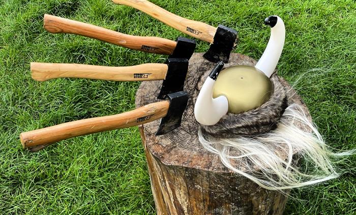 Bearded men adventures, axes in a wooden stump llangollen